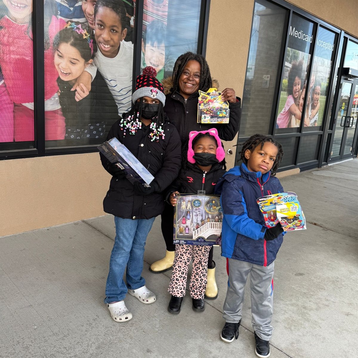 A mother and three children with their new toys outside Beauty Icon KC