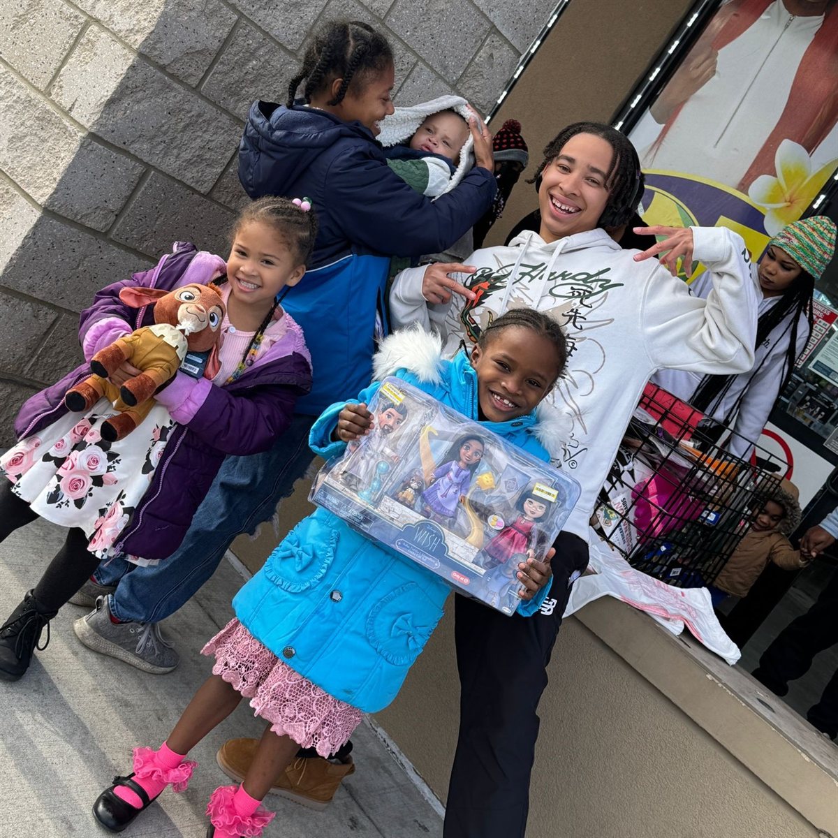 Children smiling with toys received at a Beauty Icon KC giveaway