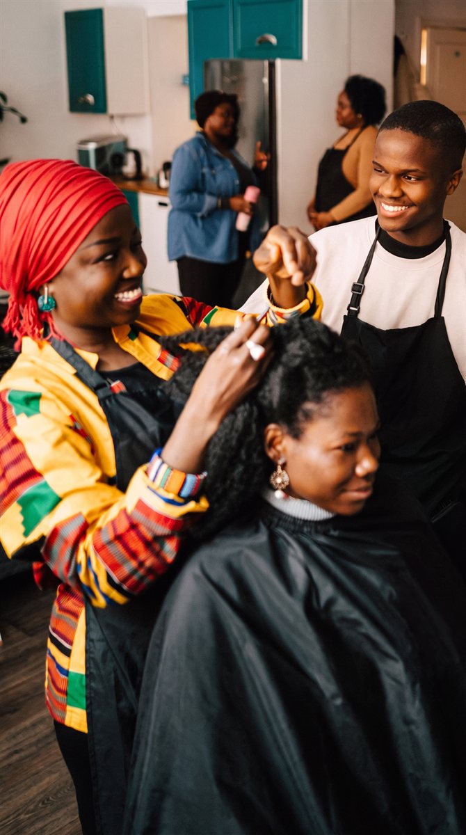 A stylist styling a client's natural hair