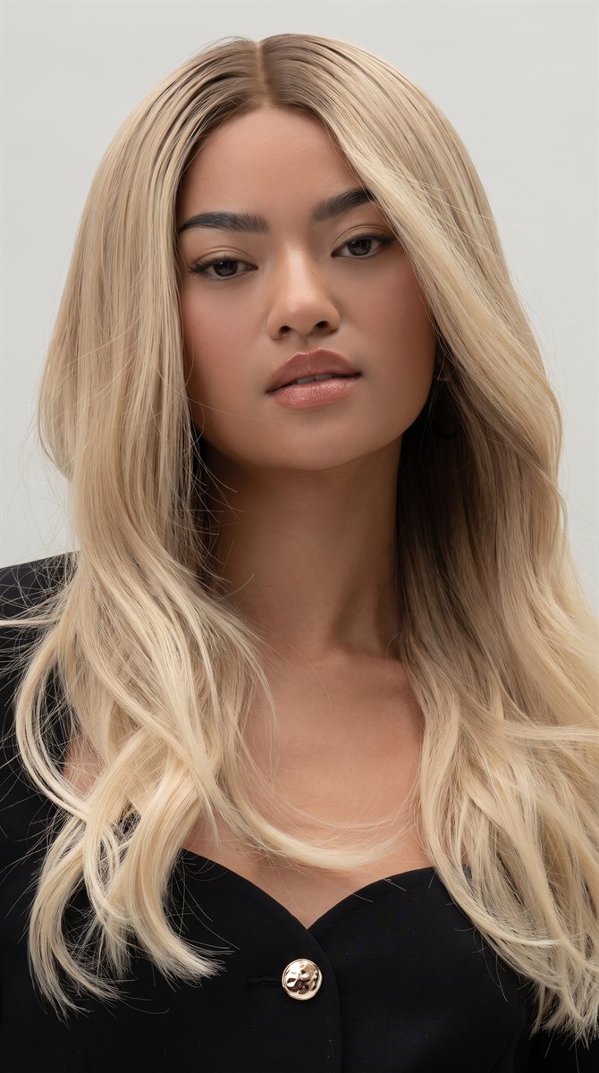 A model wearing a long, wavy blonde wig
